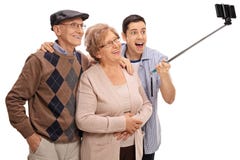 Sêniores alegres e um homem novo que toma um selfie com uma vara fotos de stock royalty free Sêniores alegres e um homem novo que toma um selfie com uma vara fotos de stock royalty free