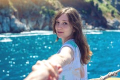 Sígame, la muchacha morena atractiva que lleva a cabo la mano lleva a las montañas y al mar azul fotos de archivo libres de regalías Sígame, la muchacha morena atractiva que lleva a cabo la mano lleva a las montañas y al mar azul fotos de archivo libres de regalías