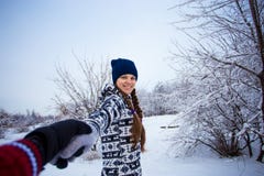Sígame Mujer joven atractiva en el sombrero que lleva a cabo la mano de su novio y caminar foto de archivo libre de regalías Sígame Mujer joven atractiva en el sombrero que lleva a cabo la mano de su novio y caminar foto de archivo libre de regalías