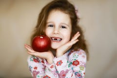 Słodka mała kędzierzawa bezzębna dziewczyna ono uśmiecha się i chwyty w jej rękach czerwony jabłko, portret szczęśliwy dziecko kt fotografia royalty free Słodka mała kędzierzawa bezzębna dziewczyna ono uśmiecha się i chwyty w jej rękach czerwony jabłko, portret szczęśliwy dziecko kt fotografia royalty free