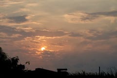 Słońce na chmurnym niebie zmrok z sylwetki miasta głąbikiem, trochę fotografia stock Słońce na chmurnym niebie zmrok z sylwetki miasta głąbikiem, trochę fotografia stock