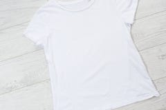 T-shirt mockup, t shirt top view. empty tshirt for logo on wooden floor copy space mock up. Casual clothes background