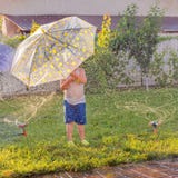 T?tigkeiten des Sommers im Freien Kinderspielen im Freien auf Vorgarten Junge mit dem Regenschirm, der Spa? nahe automatischer An lizenzfreies stockbild T?tigkeiten des Sommers im Freien Kinderspielen im Freien auf Vorgarten Junge mit dem Regenschirm, der Spa? nahe automatischer An lizenzfreies stockbild