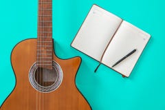 Tabela do escritor da música um espaço de trabalho com a guitarra acústica do músico e o papel do bloco de notas foto de stock Tabela do escritor da música um espaço de trabalho com a guitarra acústica do músico e o papel do bloco de notas foto de stock