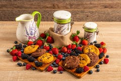 Tabela empilhada com framboesas, mirtilos, biscoitos e os receptores cerâmicos imagens de stock Tabela empilhada com framboesas, mirtilos, biscoitos e os receptores cerâmicos imagens de stock