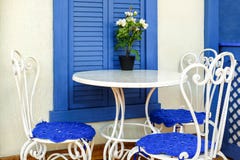 Tabla y sillas en el café a relajarse debajo de la ventana Flores en la ventana fotografía de archivo Tabla y sillas en el café a relajarse debajo de la ventana Flores en la ventana fotografía de archivo