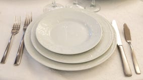 Table setting in a restaurant. Plates, forks and knives on a white tablecloth. Copy space royalty free stock photo Table setting in a restaurant. Plates, forks and knives on a white tablecloth. Copy space royalty free stock photo