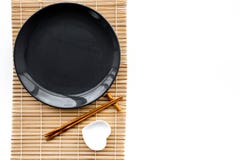 Table setting for sushi roll. Empty plate on mat near chopstick and bowl for sause on white background top view royalty free stock photography Table setting for sushi roll. Empty plate on mat near chopstick and bowl for sause on white background top view royalty free stock photography