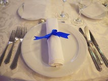 Table setup with silverware placed in the order of use, napkin and white china royalty free stock image Table setup with silverware placed in the order of use, napkin and white china royalty free stock image