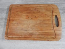 Tablero de madera para cortar las comidas en la tabla en la cocina fotos de archivo libres de regalías Tablero de madera para cortar las comidas en la tabla en la cocina fotos de archivo libres de regalías