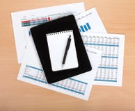 Tablet with blank screen over papers with numbers and charts Stock Images Tablet with blank screen over papers with numbers and charts Stock Images