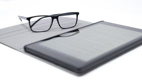 Tablet met vage teksten en glazen royalty-vrije stock afbeeldingen Tablet met vage teksten en glazen royalty-vrije stock afbeeldingen