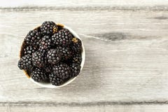 Tabletop widok, mała ceramiczna filiżanka z czernicami na szarym drewnianym biurku Przestrzeń dla teksta na dobrze zdjęcia royalty free Tabletop widok, mała ceramiczna filiżanka z czernicami na szarym drewnianym biurku Przestrzeń dla teksta na dobrze zdjęcia royalty free