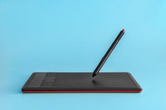 tablette graphique Noir-rouge et stylet faisant de la lévitation sur un fond bleu-clair photographie stock tablette graphique Noir-rouge et stylet faisant de la lévitation sur un fond bleu-clair photographie stock
