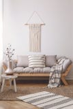 Taburete simple, de madera en una manta de mimbre en un interior pacífico de la sala de estar con una decoración hecha a mano her imagenes de archivo Taburete simple, de madera en una manta de mimbre en un interior pacífico de la sala de estar con una decoración hecha a mano her imagenes de archivo