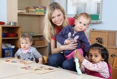 Tagesbetreuung oder Kindergartenkinder und -lehrer, die mit einem Puzzlespiel spielen stockbilder Tagesbetreuung oder Kindergartenkinder und -lehrer, die mit einem Puzzlespiel spielen stockbilder
