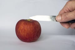 Tagli dell'uomo una mela rossa con un coltello immagini stock libere da diritti Tagli dell'uomo una mela rossa con un coltello immagini stock libere da diritti