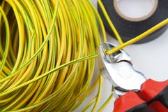 Tagliafili, con un pacco dei cavi giallo verde e del nastro elettrico fotografia stock libera da diritti Tagliafili, con un pacco dei cavi giallo verde e del nastro elettrico fotografia stock libera da diritti