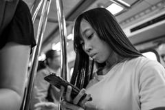 Taipeh, Taiwan - 1. Oktober 2018: Ein Schulmädchen, das ihren Handy im Taipeh MRT betrachtet lizenzfreie stockbilder Taipeh, Taiwan - 1. Oktober 2018: Ein Schulmädchen, das ihren Handy im Taipeh MRT betrachtet lizenzfreie stockbilder
