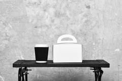 Take away coffee and white package on table. stock images Take away coffee and white package on table. stock images