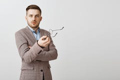 Talia strzelał intensywny zmieszany atrakcyjny męski przedsiębiorca w eleganckiej kurtce bierze daleko szkła i gestykuluje z zdjęcie stock Talia strzelał intensywny zmieszany atrakcyjny męski przedsiębiorca w eleganckiej kurtce bierze daleko szkła i gestykuluje z zdjęcie stock