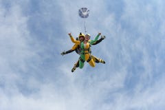 Tandemowy skydiving Aktywna dziewczyna lata w niebieskim niebie zdjęcie stock Tandemowy skydiving Aktywna dziewczyna lata w niebieskim niebie zdjęcie stock