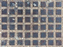 Tapa de la alcantarilla de cuarenta y ocho cuadrados metálicos para el fondo fotografía de archivo Tapa de la alcantarilla de cuarenta y ocho cuadrados metálicos para el fondo fotografía de archivo