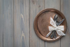 Tappningkniv, sked och gaffel på en metallplatta på en grå träbakgrund fotografering för bildbyråer Tappningkniv, sked och gaffel på en metallplatta på en grå träbakgrund fotografering för bildbyråer