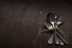 Tappningsilverskedar, gafflar och kniv på svart bakgrund för tappning Låg-tangent arkivbilder Tappningsilverskedar, gafflar och kniv på svart bakgrund för tappning Låg-tangent arkivbilder