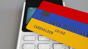 Tarjeta de banco plástica que ofrece la bandera de Armenia y del terminal del pago de la posición Sistema bancario armenio o 3D r metrajes Tarjeta de banco plástica que ofrece la bandera de Armenia y del terminal del pago de la posición Sistema bancario armenio o 3D r metrajes