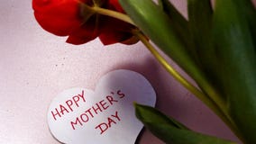 Tarjeta de felicitación en la forma de un corazón con el día de madre feliz de las palabras, tulipanes rojos con gratitud Tarjeta de felicitación en la forma de un corazón con el día de madre feliz de las palabras, tulipanes rojos con gratitud