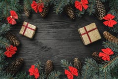 Tarjeta de felicitación de Navidad El abeto ramifica con los conos y los cuencos rojos, en fondo de madera negro Weihnachtspakete fotos de archivo libres de regalías Tarjeta de felicitación de Navidad El abeto ramifica con los conos y los cuencos rojos, en fondo de madera negro Weihnachtspakete fotos de archivo libres de regalías
