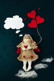 Tarjeta del día de San Valentín hecha en casa con un ángel de una tela que lleva corazones y sueños de un querido en un fondo osc imagen de archivo Tarjeta del día de San Valentín hecha en casa con un ángel de una tela que lleva corazones y sueños de un querido en un fondo osc imagen de archivo
