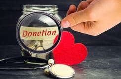 Tarro de cristal con las monedas, corazón y estetoscopio y la inscripción ‘donación ‘ Concepto de la medicina transfusión de sang fotografía de archivo libre de regalías Tarro de cristal con las monedas, corazón y estetoscopio y la inscripción ‘donación ‘ Concepto de la medicina transfusión de sang fotografía de archivo libre de regalías