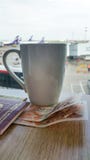 Tasse de café dans l'aéroport Passeport et argent sur la table Avions, autobus et pont en jet brouillé sur le fond photos stock Tasse de café dans l'aéroport Passeport et argent sur la table Avions, autobus et pont en jet brouillé sur le fond photos stock