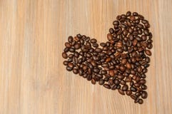 Tasse lumineuse avec des grains de café et des bonbons sur une table en bois photo stock Tasse lumineuse avec des grains de café et des bonbons sur une table en bois photo stock