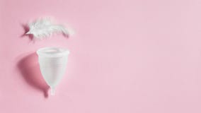 Tasse menstruelle sur le fond rose, hygiène féminine photos stock Tasse menstruelle sur le fond rose, hygiène féminine photos stock