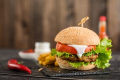 Tasty hamburger with meat and vegetables against a dark background royalty free stock images Tasty hamburger with meat and vegetables against a dark background royalty free stock images