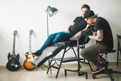 Tattoo machine make drawing on male hand. stock image Tattoo machine make drawing on male hand. stock image