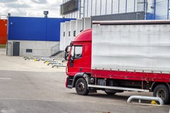 Tauschen Sie nahe Logistikmitte an der Entleerung oder am Laden der Fracht in Behälter Transport des Warenkonzeptes LKW nahe Lage lizenzfreie stockfotos Tauschen Sie nahe Logistikmitte an der Entleerung oder am Laden der Fracht in Behälter Transport des Warenkonzeptes LKW nahe Lage lizenzfreie stockfotos