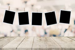 Tavola di legno vuota e foto istantanea che appendono sul backgro di immagine di sfuocatura Fotografia Stock Libera da Diritti Tavola di legno vuota e foto istantanea che appendono sul backgro di immagine di sfuocatura Fotografia Stock Libera da Diritti