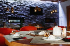 Tavola di tè sui precedenti di una parete porpora immagini stock libere da diritti Tavola di tè sui precedenti di una parete porpora immagini stock libere da diritti