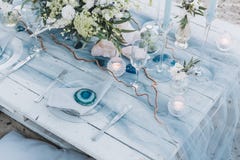Tavola elegante installata in pastelli blu per le nozze di spiaggia immagini stock Tavola elegante installata in pastelli blu per le nozze di spiaggia immagini stock