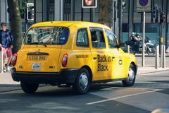 Taxi amarillo británico famoso en la calle de Londres el día soleado imagen de archivo libre de regalías Taxi amarillo británico famoso en la calle de Londres el día soleado imagen de archivo libre de regalías