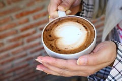 Tazza della tenuta della donna del caffè caldo della moca in sua mano nel caffè durante la stagione invernale immagine stock Tazza della tenuta della donna del caffè caldo della moca in sua mano nel caffè durante la stagione invernale immagine stock