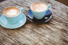 Tazza di cappuccino con arte del caffè sulla tavola di legno immagini stock Tazza di cappuccino con arte del caffè sulla tavola di legno immagini stock