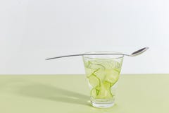 Tazza di vetro con acqua del cetriolo su un fondo verde chiaro Concetto creativo di Minimalistic Copi lo spazio fotografia stock Tazza di vetro con acqua del cetriolo su un fondo verde chiaro Concetto creativo di Minimalistic Copi lo spazio fotografia stock