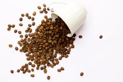 Tazza e fagioli di caffè su una priorità bassa bianca fotografia stock Tazza e fagioli di caffè su una priorità bassa bianca fotografia stock