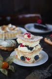 Tea And Sweets On A Dark Background, Mille-feuille, Eclairs, Tart, Decorative With Flowers, Selective Focus, Closeup Stock Photo Tea And Sweets On A Dark Background, Mille-feuille, Eclairs, Tart, Decorative With Flowers, Selective Focus, Closeup Stock Photo