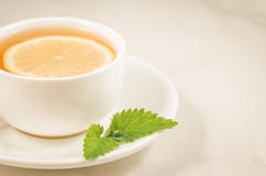 Tea Cup With A Lemon And Mint/tea Cup With A Lemon And Mint On A White Marble Background Closeup. Selective Focus Stock Photo Tea Cup With A Lemon And Mint/tea Cup With A Lemon And Mint On A White Marble Background Closeup. Selective Focus Stock Photo